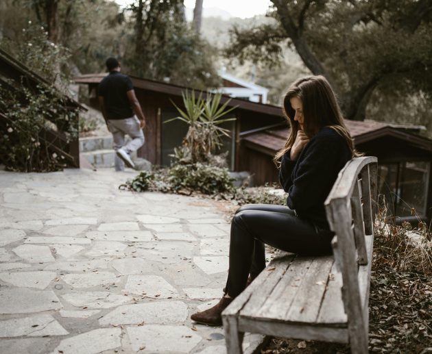 Person checking phone anxiously — how to stop being clingy in a relationship