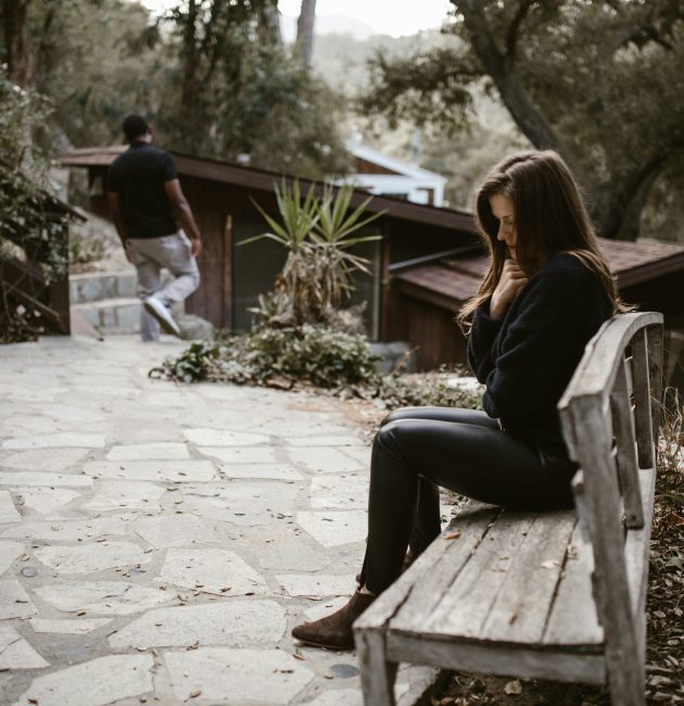 Person checking phone anxiously — how to stop being clingy in a relationship