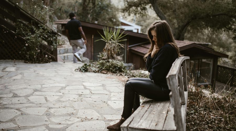 Person checking phone anxiously — how to stop being clingy in a relationship